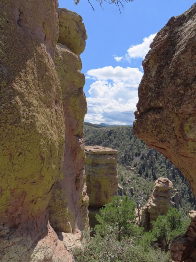 Two towering rock formations with a view between them to the distant landscape.