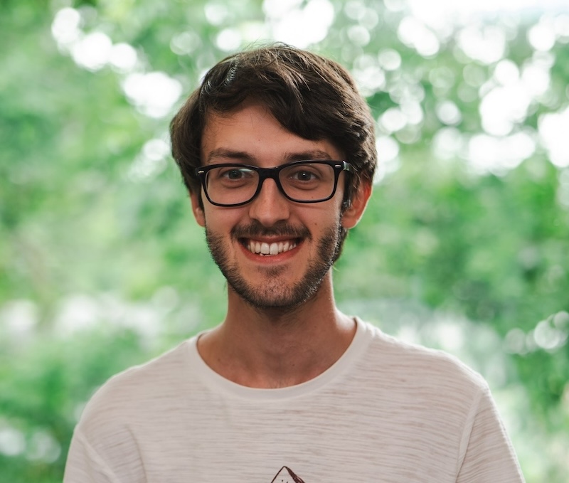 Smiling man with black eyeglasses.