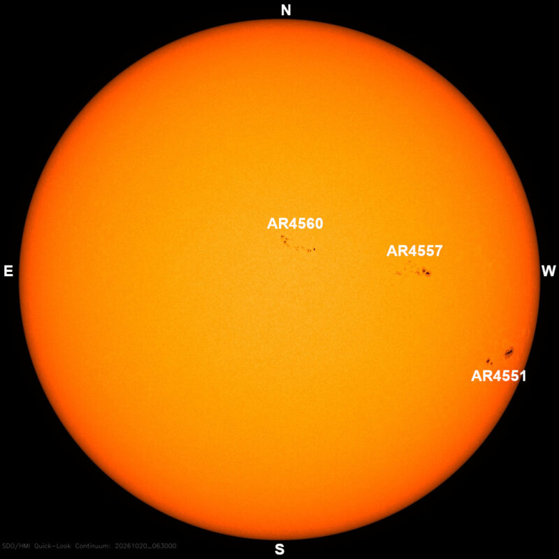 The sun in visible light, a yellow disk with a few small dark sunspots, each labeled with its active region number.