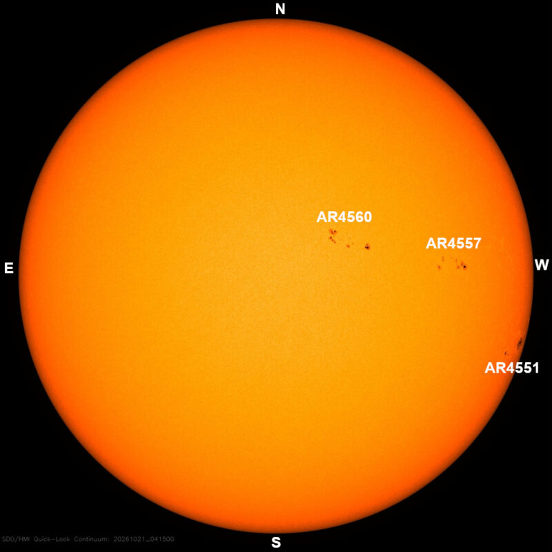 The sun in visible light, a yellow disk with a few small dark sunspots, each labeled with its active region number.
