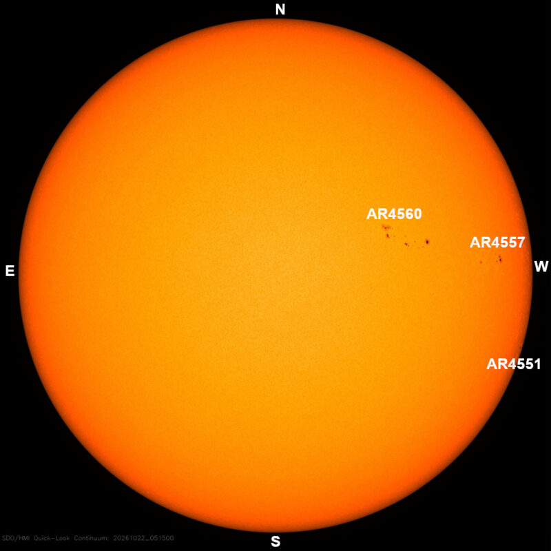 The sun in visible light, a yellow disk with a few small dark sunspots, each labeled with its active region number.