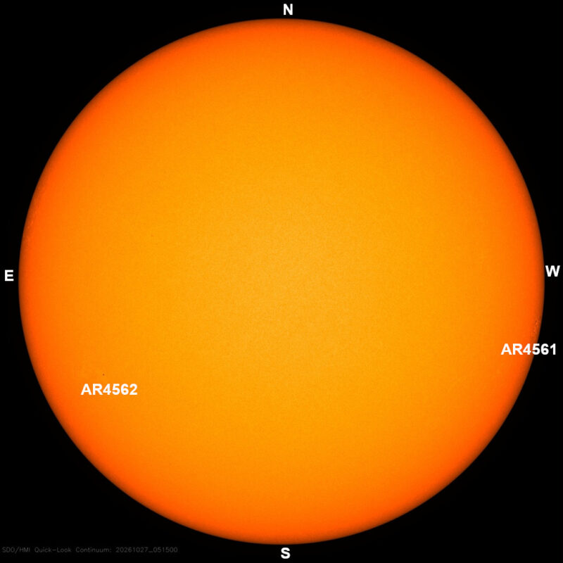 The sun in visible light, a yellow disk with a few small dark sunspots, each labeled with its active region number.