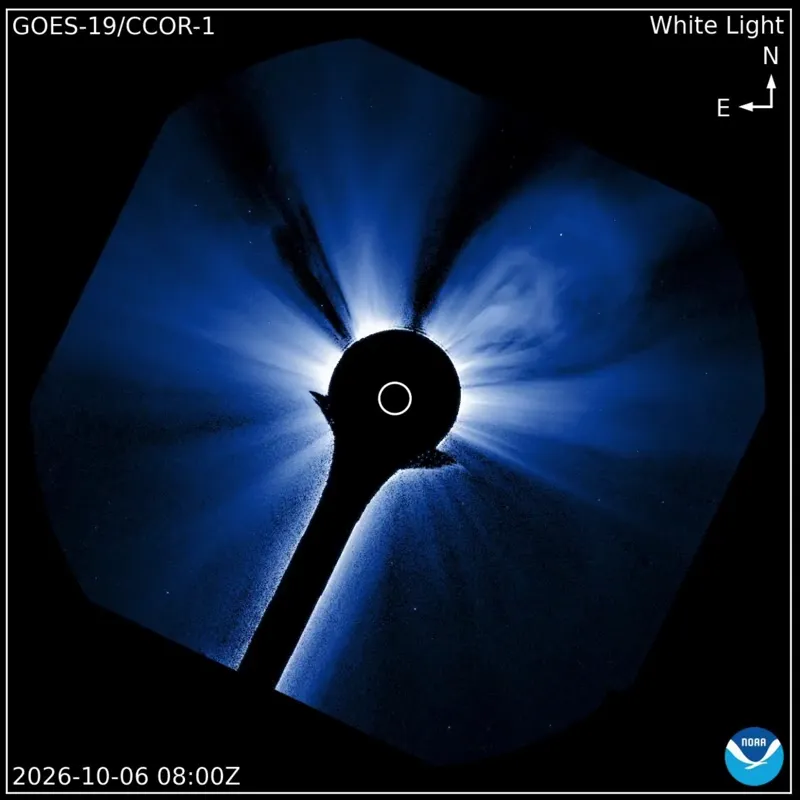 Coronagraph view with the sun hidden behind a dark disk, as a faint cloud of solar material expands outward on all sides.