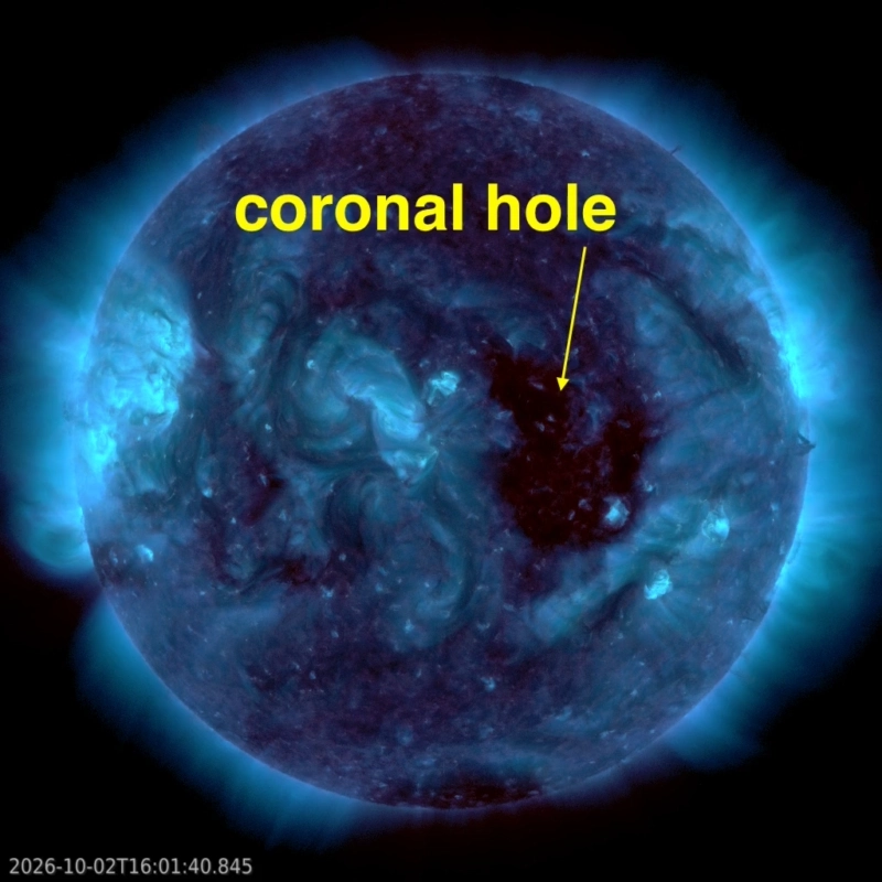 The sun in blue extreme ultraviolet light, with a large dark coronal hole just west of center and bright active regions.